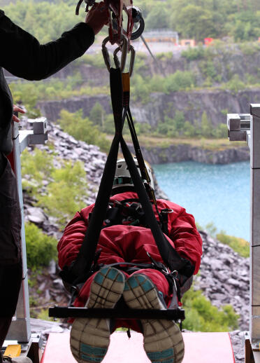 A person about to launch off on a zip wire above a lake.