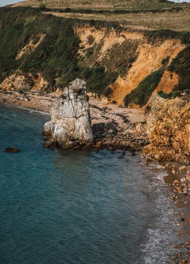 Cliffs, sea and white quartzite sea stack.