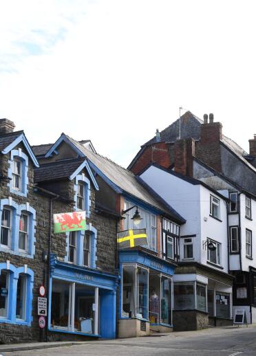 Eine Straße voller Geschäfte mit walisischen Flaggen.