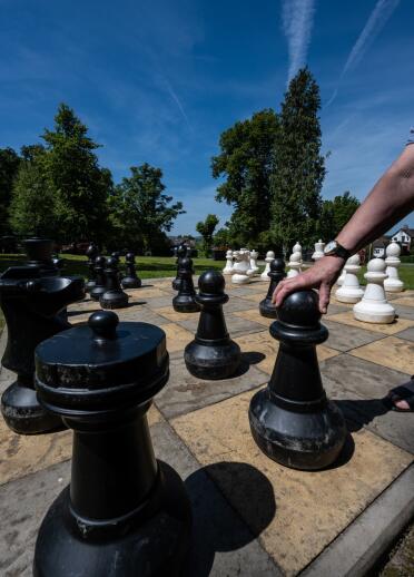 People playing on a large outdoor chess set.