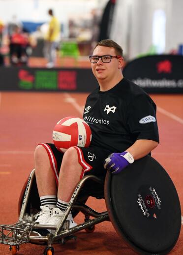 A man in a wheelchair holding a ball.