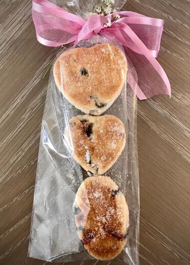 three Welsh cakes in packaging shaped like a love spoon.