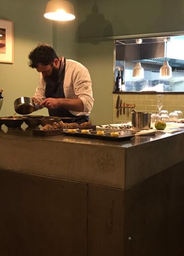 A chef preparing food in a kitchen area inside a restaurant.