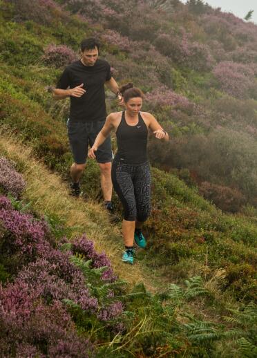 runners on path with heather covered Great Orme.