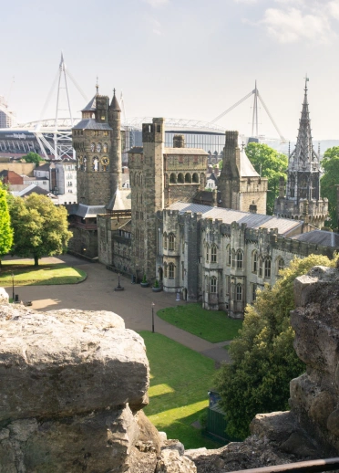 view of inner castle and modern buildings from keep with woman looking at the view.