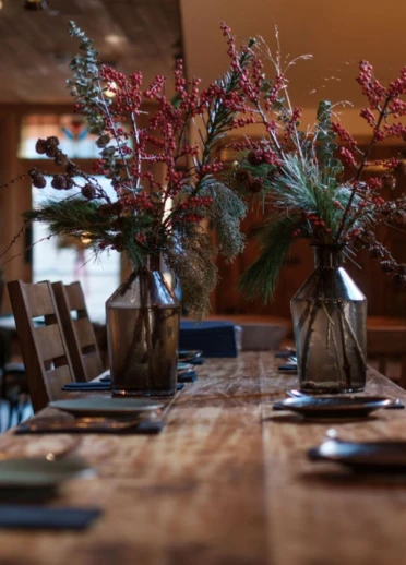table in restaurant with vases of berries.