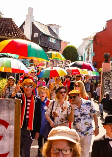 Crowds at Portmeirion, some with brightly coloured umbrellas. 