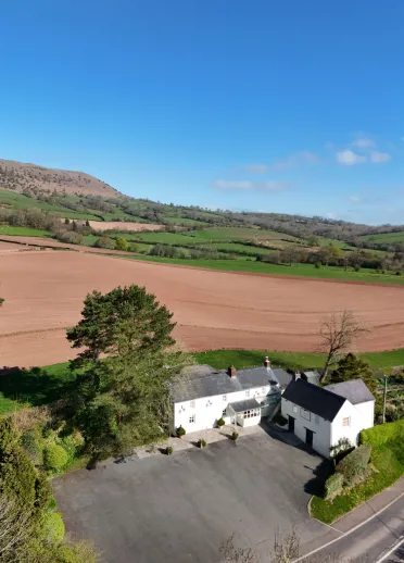 Two whitewashed cottages in the countryside.