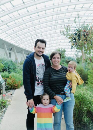 Young family posing for a photo in the glasshouse at the National Botanic Gardens