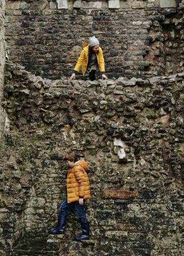 Kinder erforschen die Mauern einer alten Burg.