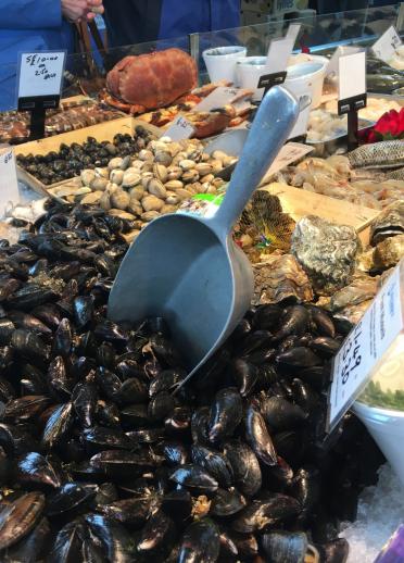 Seafood stall in market - foreground mussels with scoop