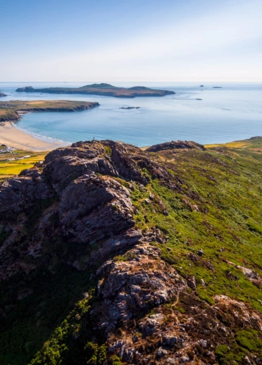 Looking our over a cliff towards a wide sandy beach.