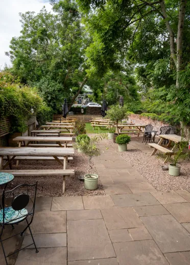 Some wooden benches in a courtyard for a coffee a coffee shop