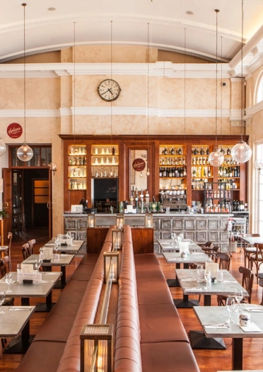 inside view of a restaurant with tables and chairs and the bar.