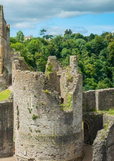 Two towers inside Chepstow Castle showing the ruins of war.