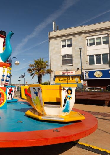 Supersized tea cups on a children's merry go round ride at Barry Island Pleasure Park.