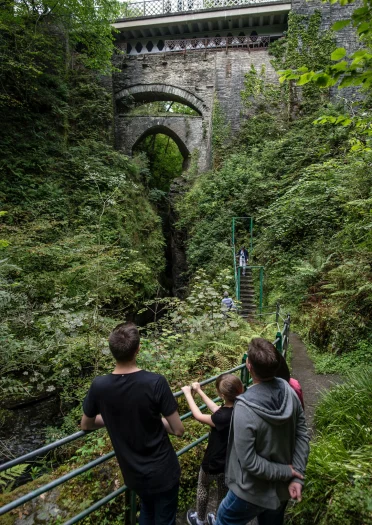 Family looking up a Devil's Bridge from railings beneith