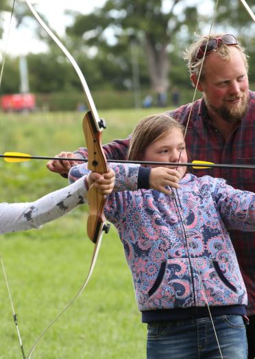 Image of two girls learning archery at The Good Life Experience
