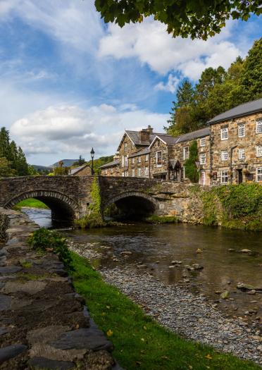 Houses in Beddgelert, Snowdonia, North Wales take from across the river over the stone bridge.