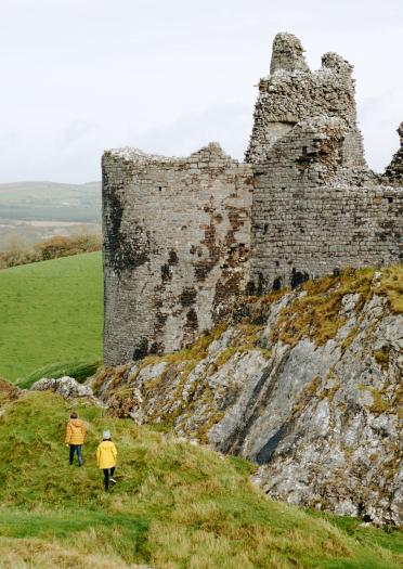 Exterior of a partially ruined castle on a hill.