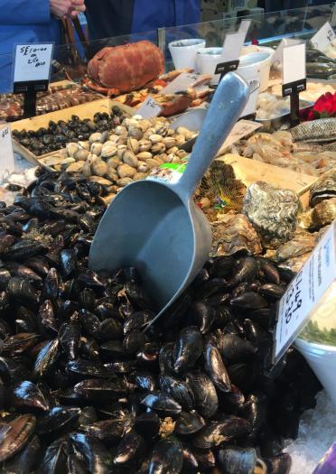 Seafood stall in market - foreground mussels with scoop