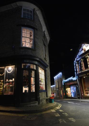 exterior of bookshops at night with Christmas decorations and lights.