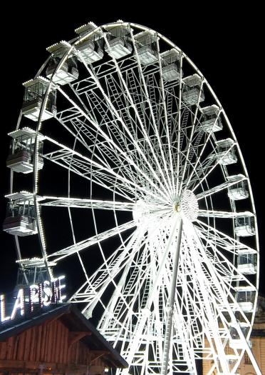 big wheel lit up at night.