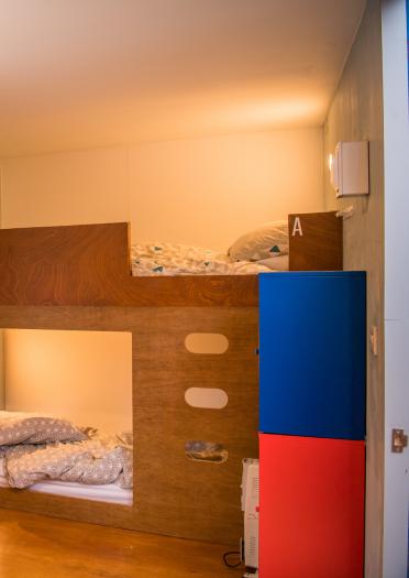 Inside a bunkhouse bedroom. a bunk bed and chair.