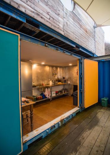 bunkhouse with doors open looking into kitchen interior. 
