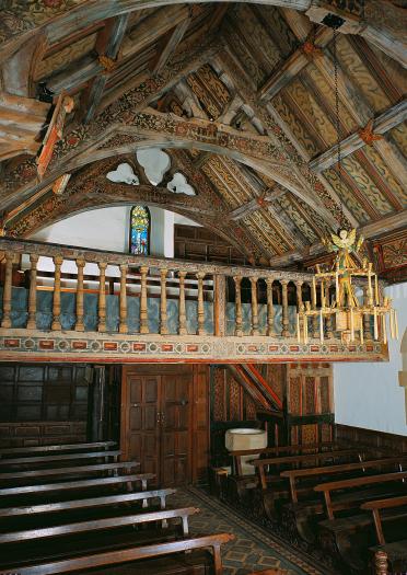 Interior of church with wooden ceiling and balcony.