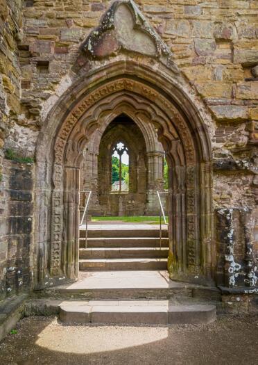 Exterior shot of an archway and steps of an abbey