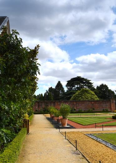 Manor house gardens with pathways and surrounded by red brick walls