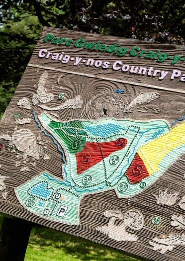 Craig-y-Nos Country Park wooden sign and map.