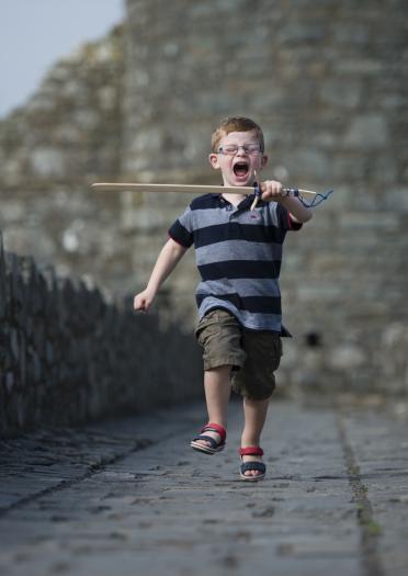 boy with sword marching on castle walls.