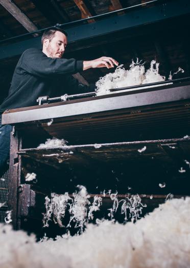 man using large wool machine.
