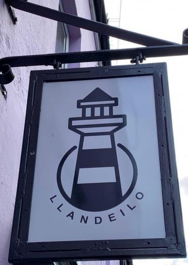 Ladenschild mit Leuchtturm und dem Wort Llandeilo.