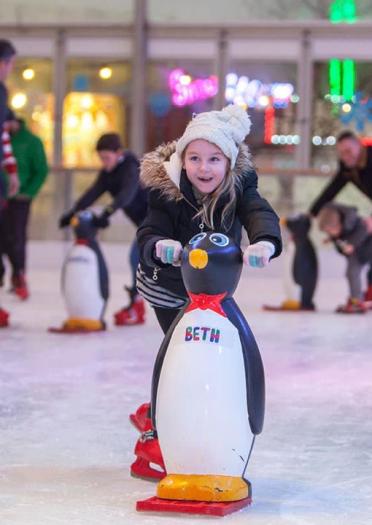 girl skating holding a penguin skate aid.