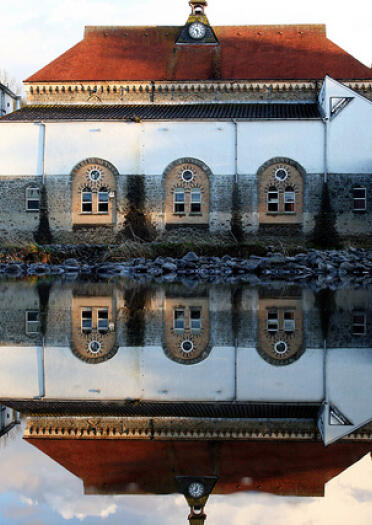 buildings and bridge reflected in water.