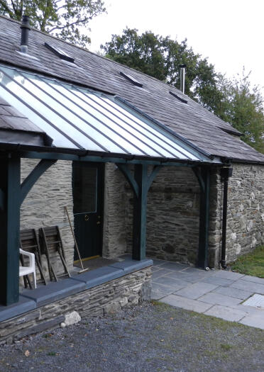 Exterior front entrance of a stone cottage with wheelchair access.