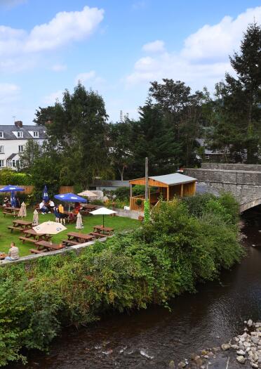 beer garden and canal with stone bridge.