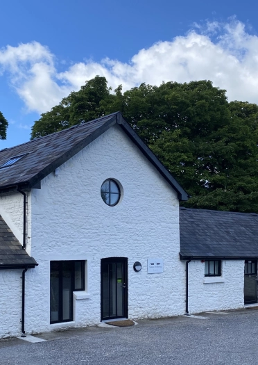 Exterior of a white painted stable building.
