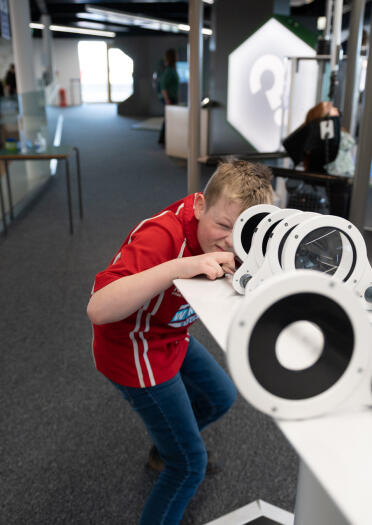 A boy using a telescope.