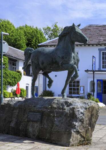 A bronze horse sculpture in a town.