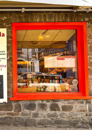A food and drink shop with red doors and window frames.