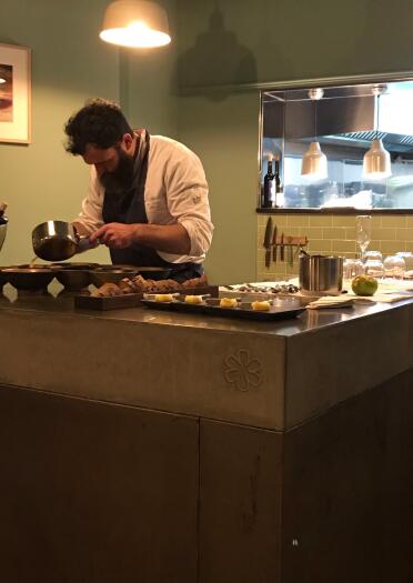 A chef preparing food in a kitchen area inside a restaurant.