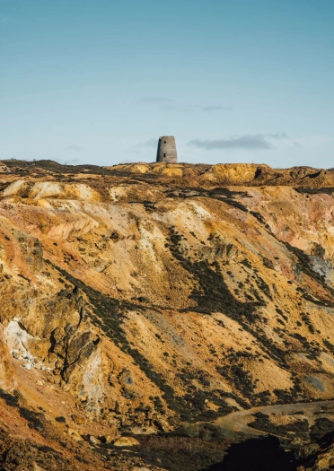 A quarry with colourful layers of ground, mainly yellow. 