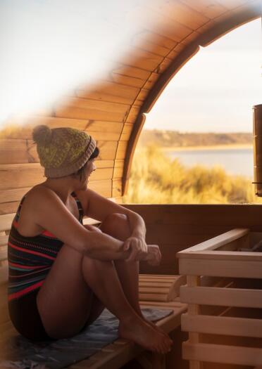 man and woman in sauna looking out to beach.