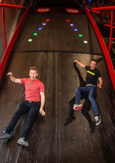Two adults on a big slide.