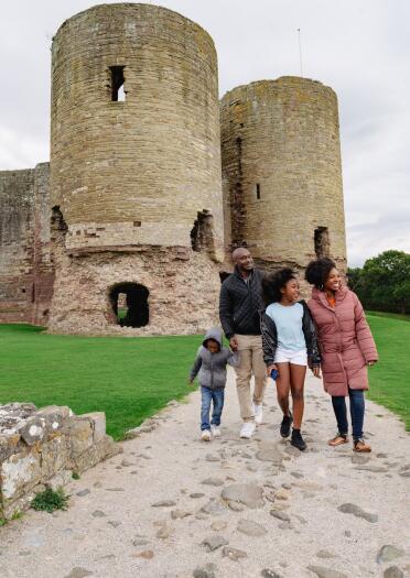 Two adults and two children exploring a partially ruined castle. 