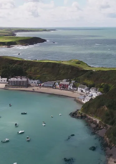 A serene coastal cove with a charming cafe nestled within, offering picturesque views of the sea